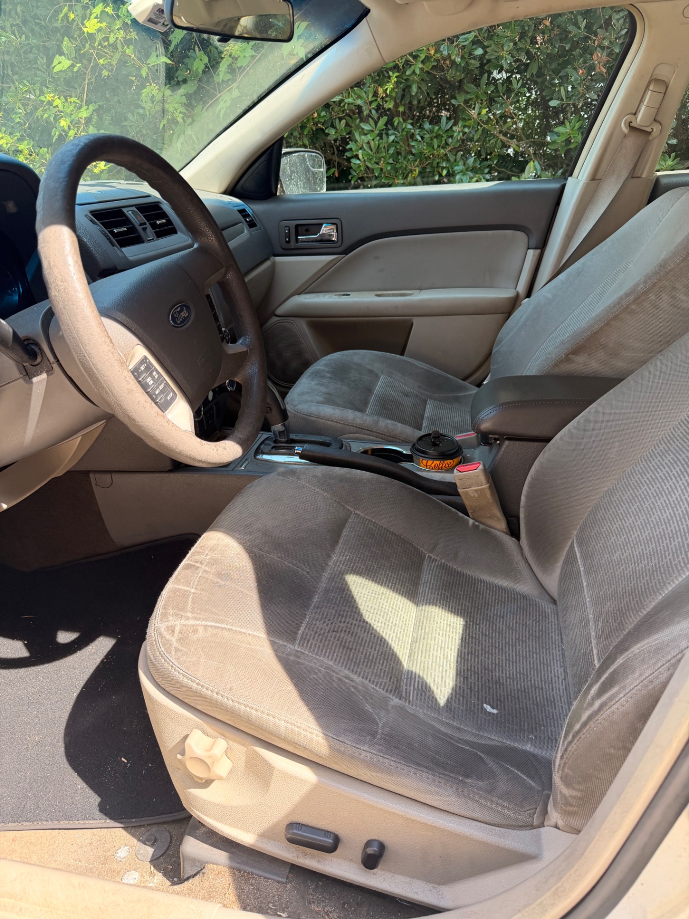 Stained beige front car seat before an interior shampoo